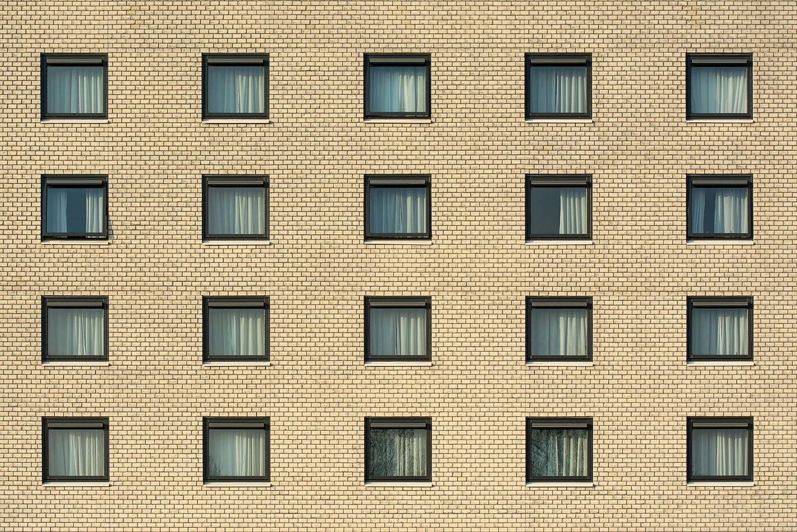 Bâtiment de brique jaune avec fenêtres régulières