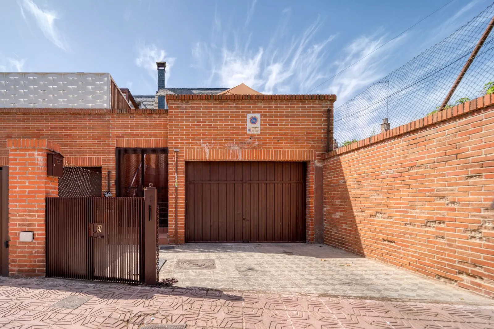Maison de brique avec portail et porte de garage
